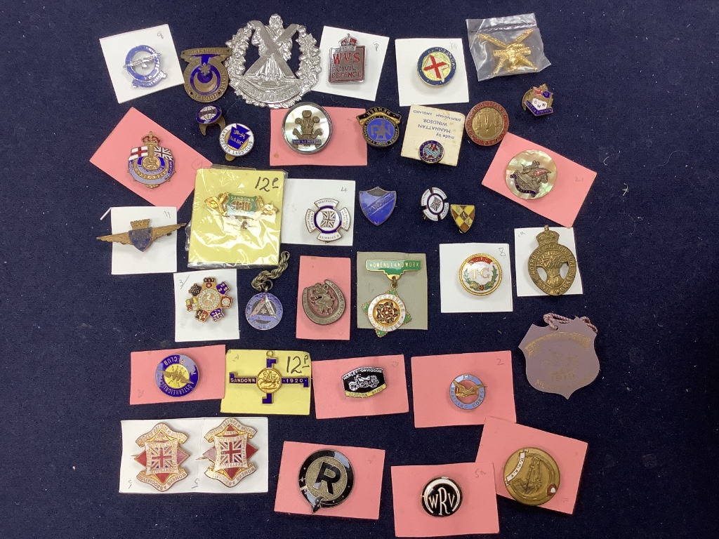 A collection of assorted enamel badges and nursing badges